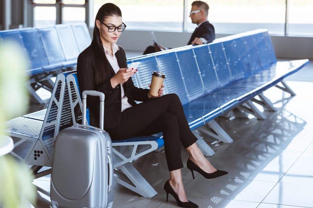 Woman at airport holding her phone.